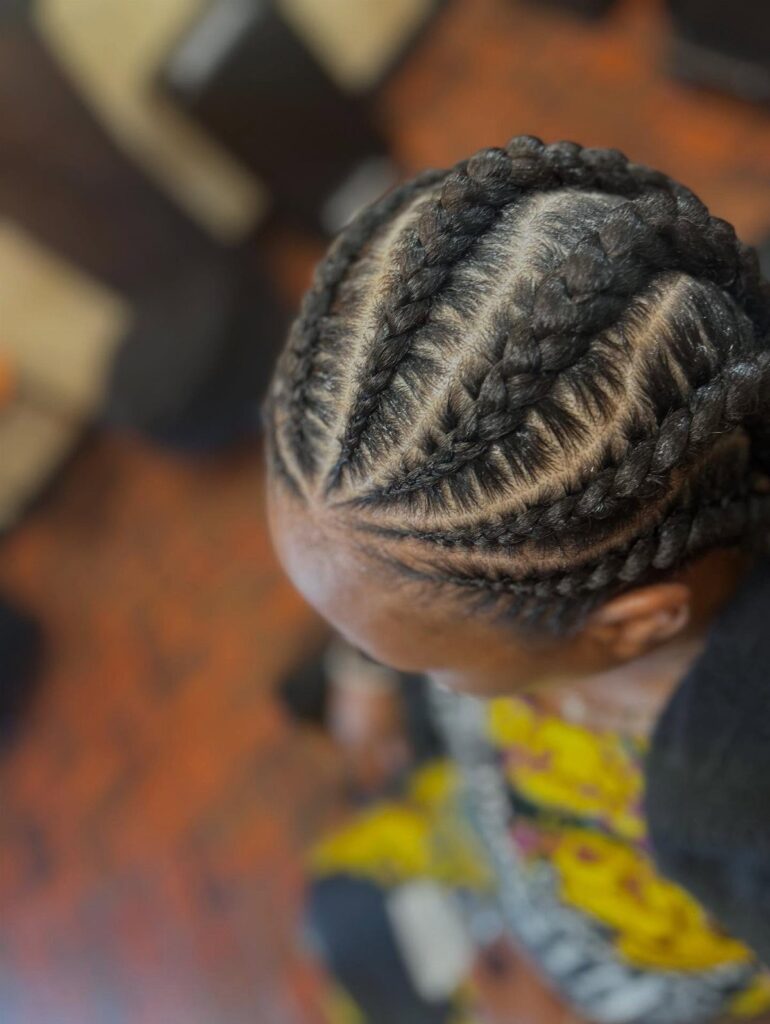 Cornrow braids styled in curved lines across a person's scalp from above.