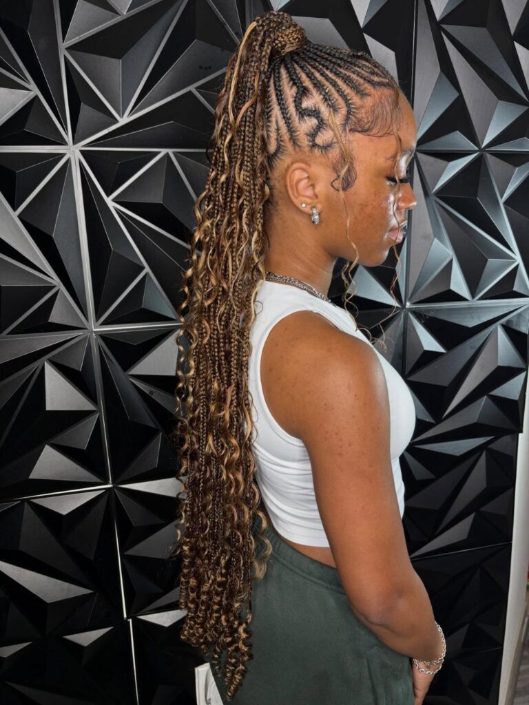 Woman with a high slicked-back braided ponytail in brown and blonde tones.