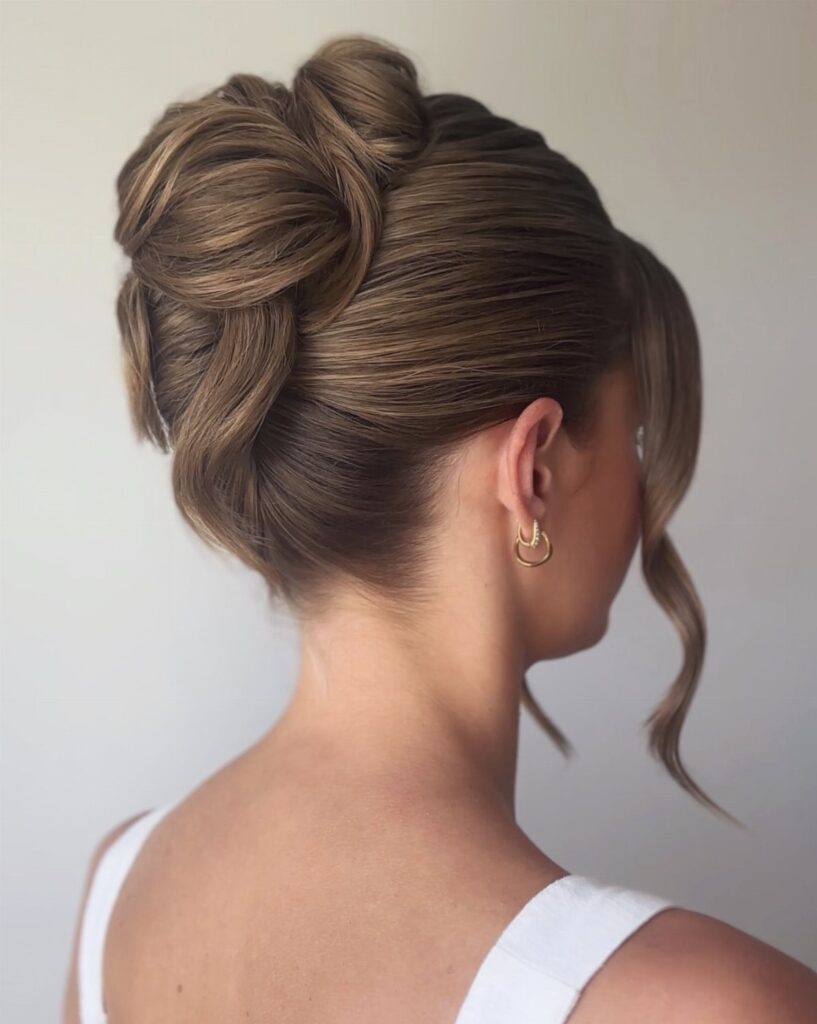 Woman with light brown hair styled in an elegant, voluminous updo bun.