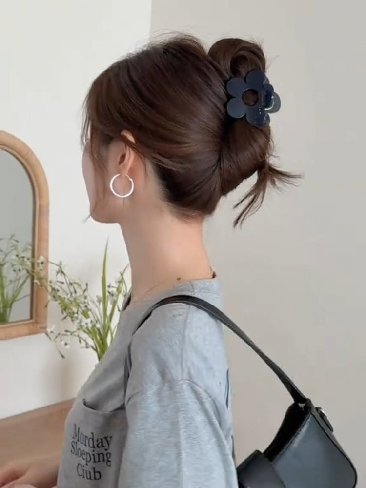 Woman with brown hair in a twisted updo secured by a flower claw clip