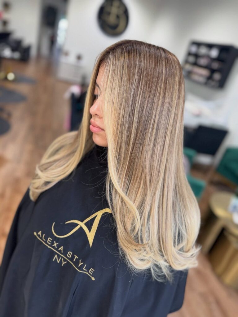 Woman with honey brown hair and golden blonde highlights styled in loose waves