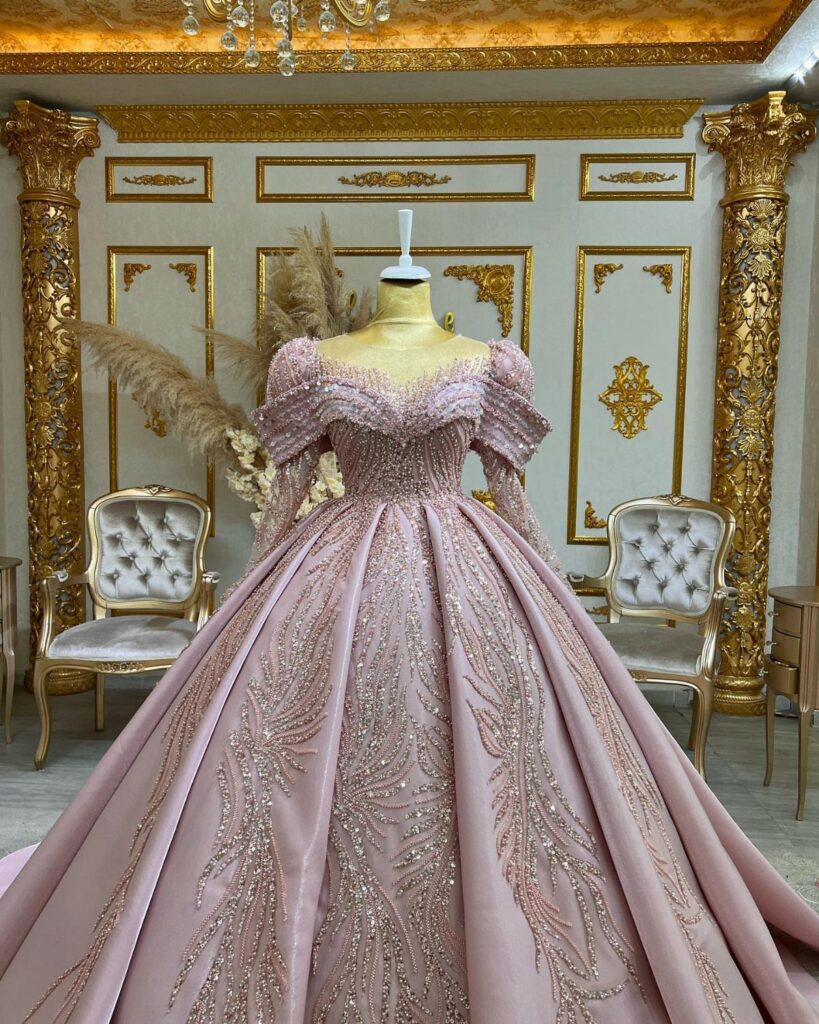 Dramatic pink ballgown with voluminous skirt and shimmering embroidery on a mannequin