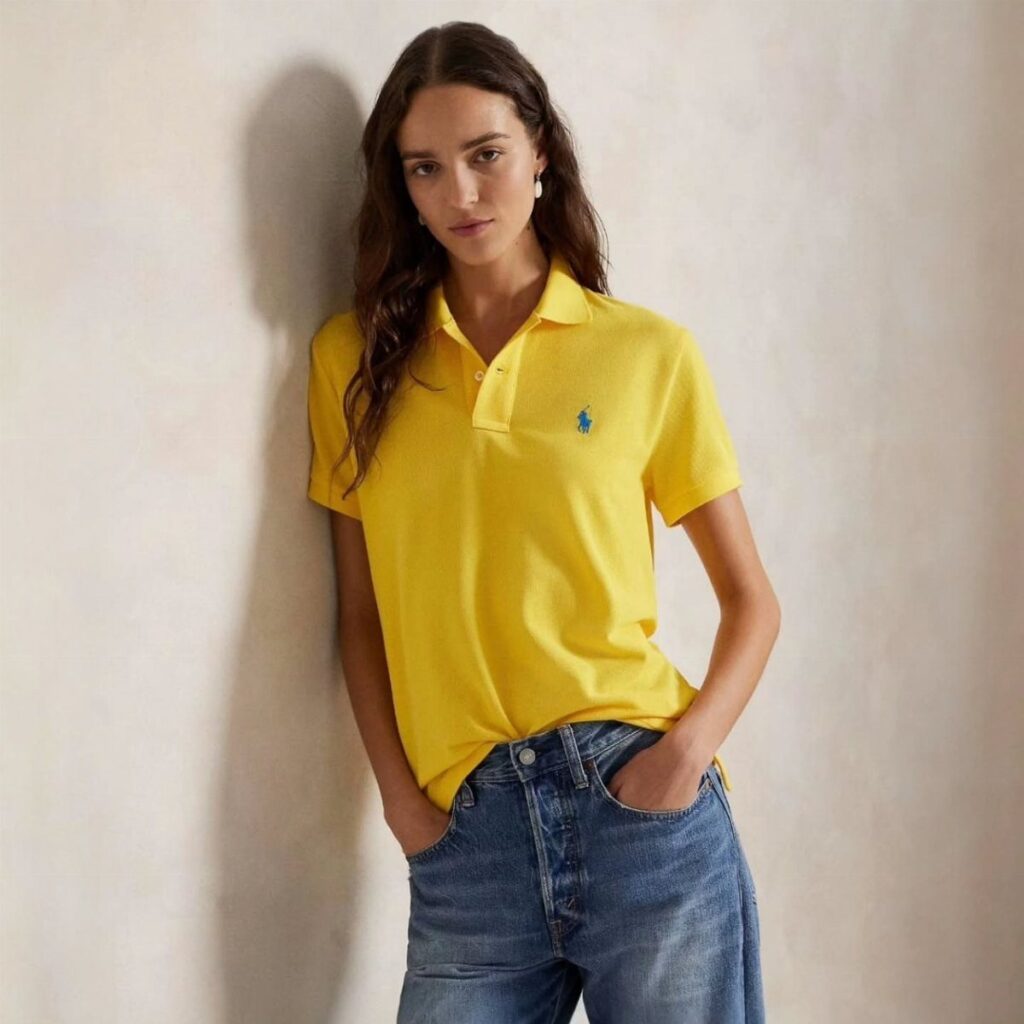 Woman wearing a yellow Ralph Lauren polo shirt and blue denim jeans.